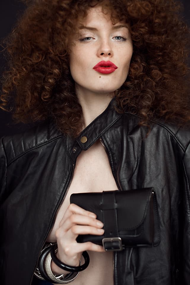 Stylizacja z rudymi lokami i makijażem glamour z czerwonymi ustami.